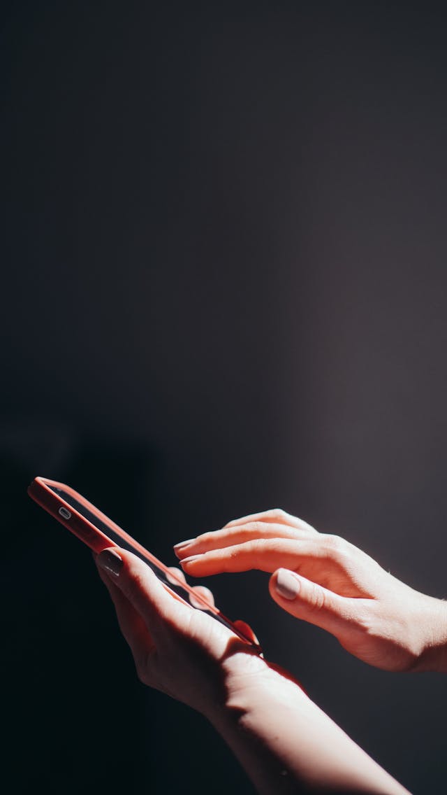 スマートフォンを見る人物の無料素材写真